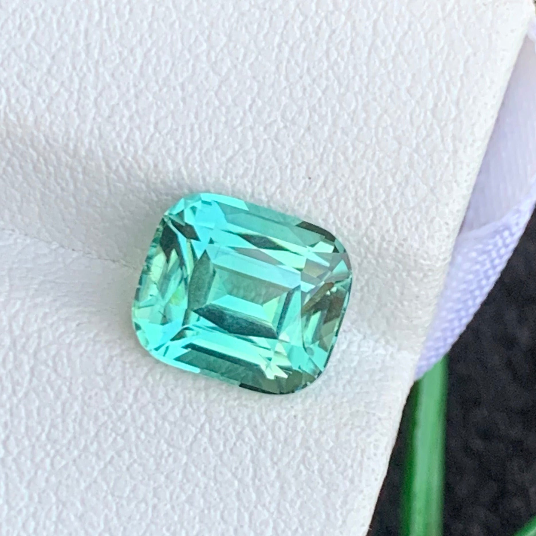 Cushion cut seafoam tourmaline gemstone close-up
Eye clean natural greenish tourmaline gemstone