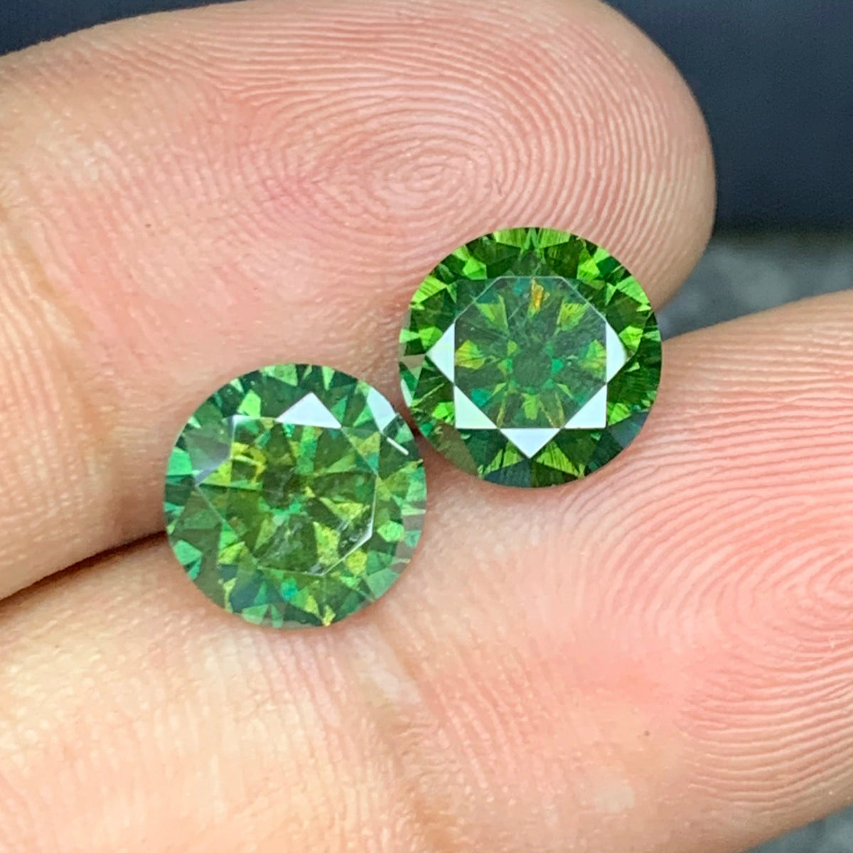 Green moissanite pair held for scale
Moissanite pair reflecting light showing brilliance and fire