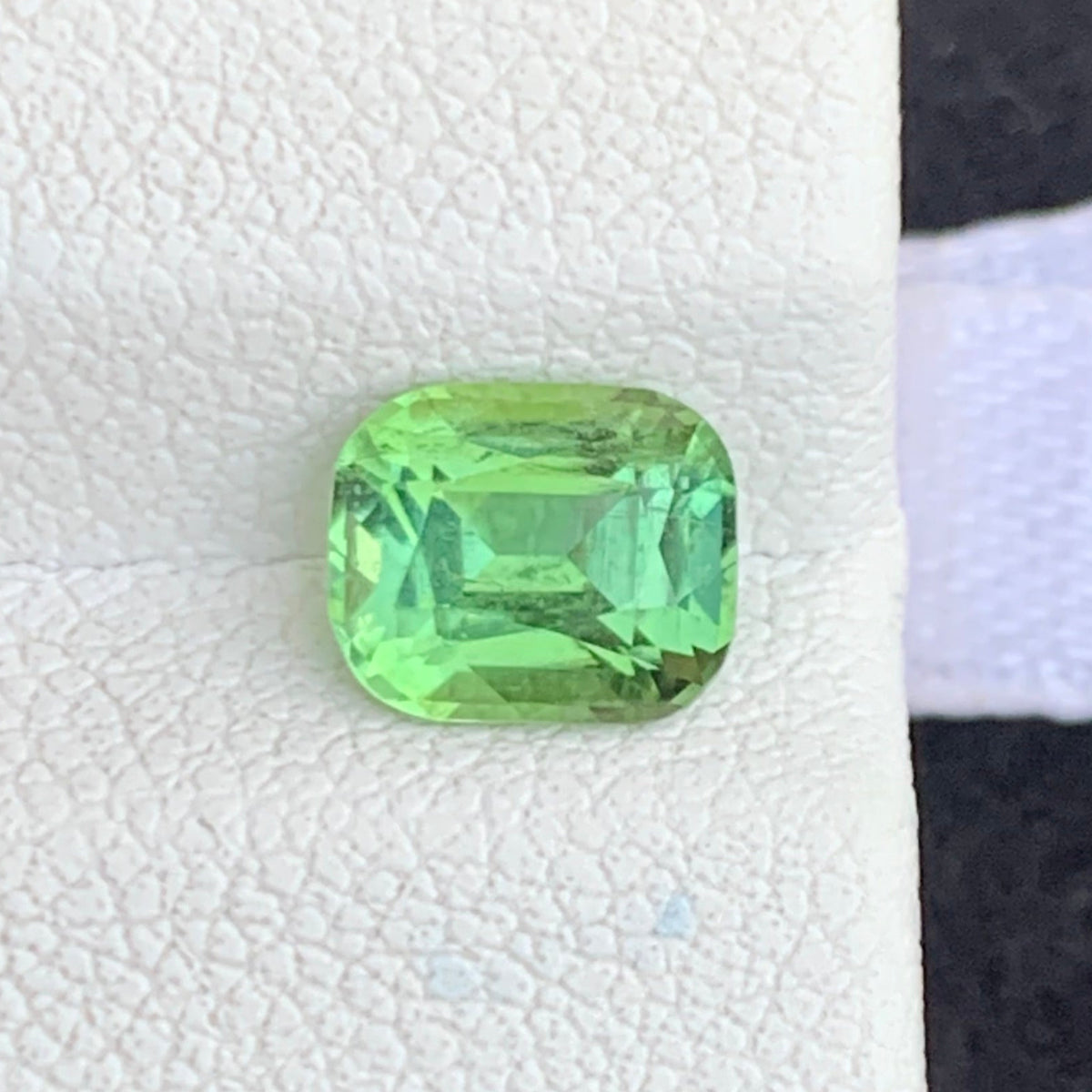 Cushion cut gemstone dimensions 6.84 x 5.71 x 4.28mm
Forest green tourmaline held for scale