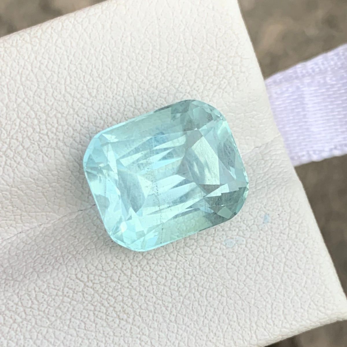 Ocean blue aquamarine loose stone on white background
Cushion cut gemstone dimensions 12.80 x 10.31 x 8.32mm