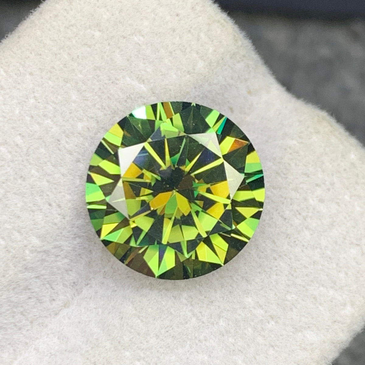 Round cut moissanite 6.10 ct showing fire and brilliance
Yellowish green moissanite with GRA certificate