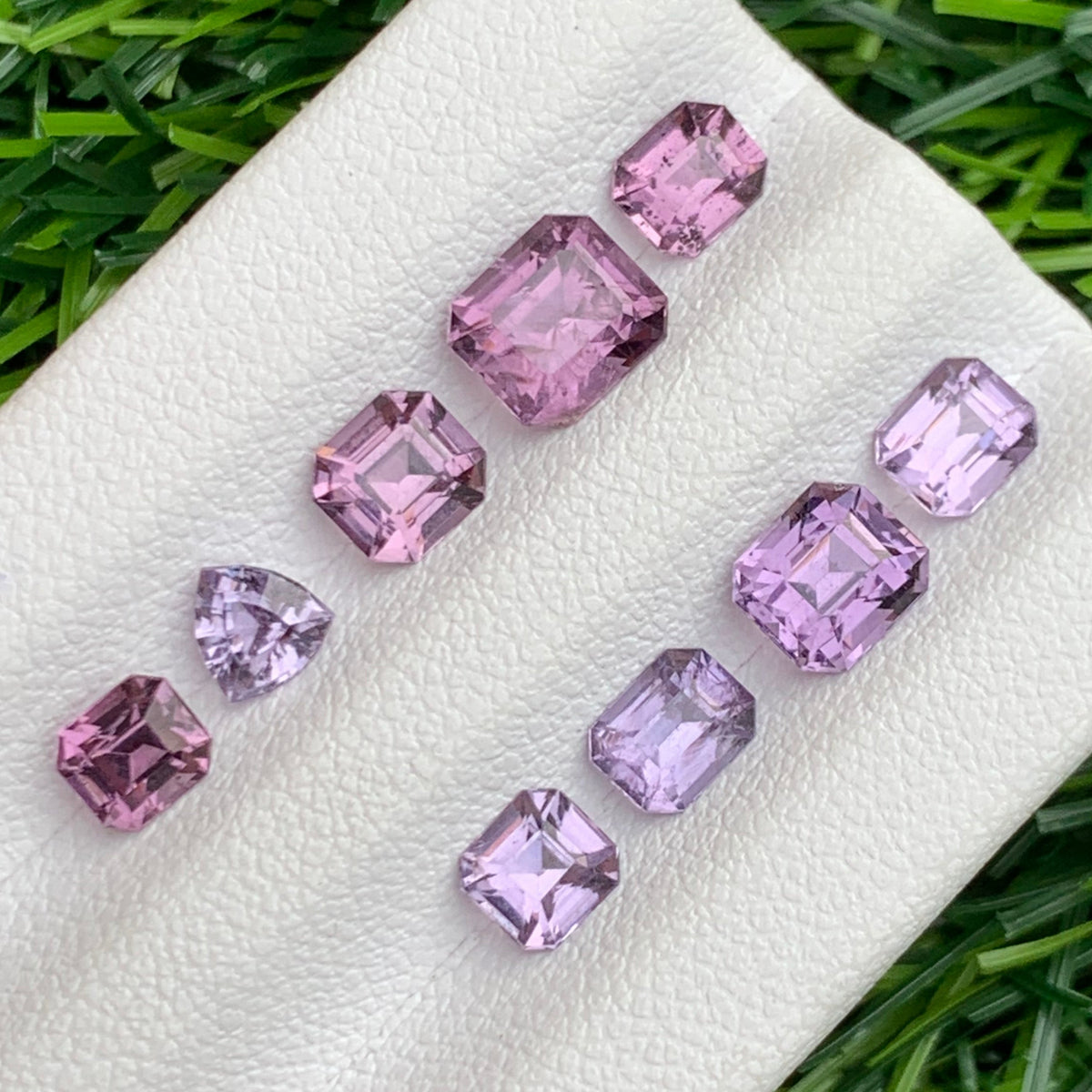 Pink purple spinel gemstones held for scale
Spinel lot reflecting light showing diamond-like sparkle